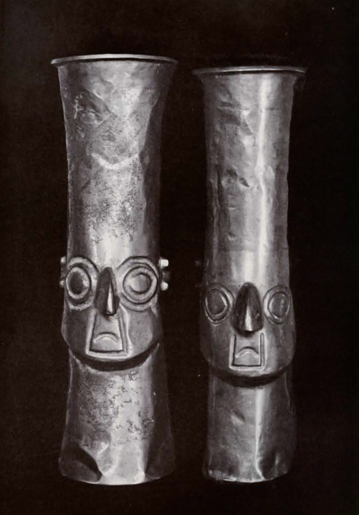 Two tall cylindrical vases with faces in repousse