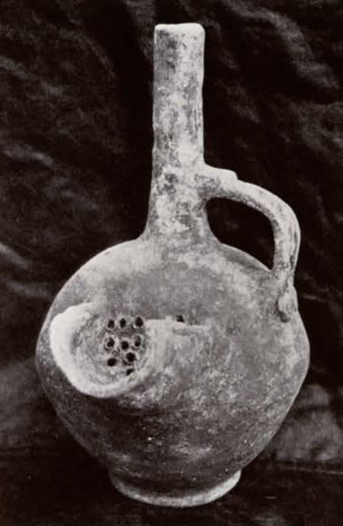 Pot with spherical body and long neck with one handle and spout with filter