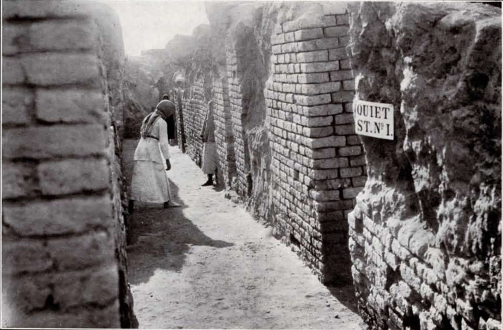 Man standing in the excavated Quiet Street showing brick walls