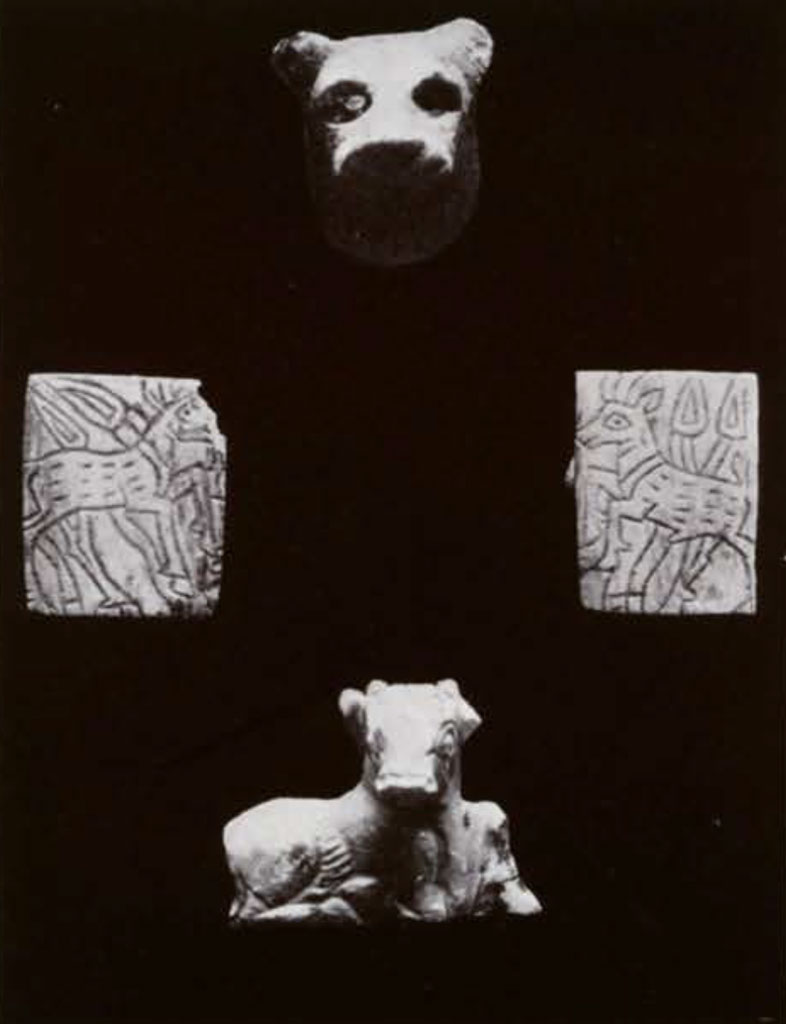 A small bull and lion head figurine, and two shell plaques with goats