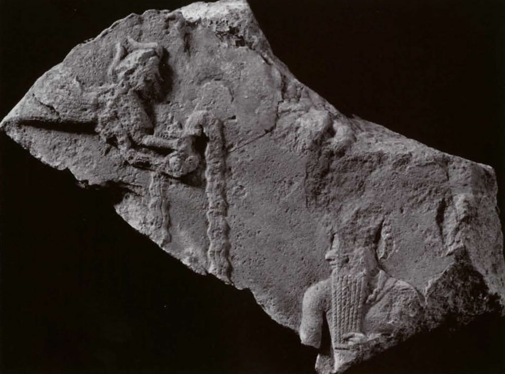 Fragment of a stela showing a flying angel with an overflowing vase bringing it to a king