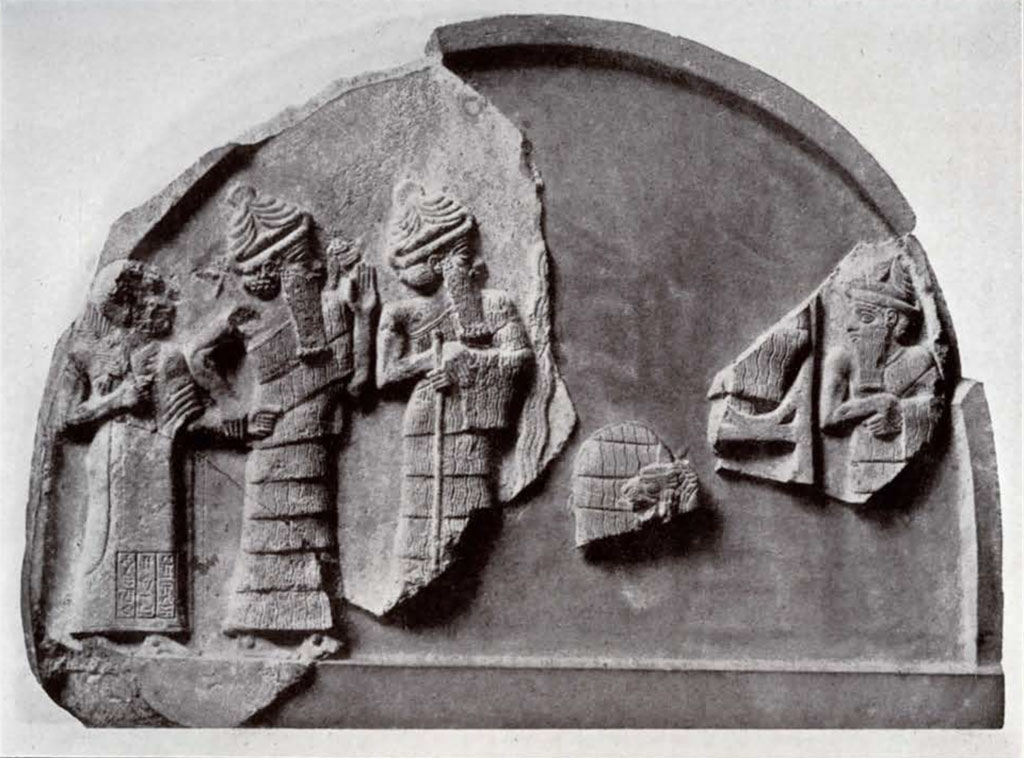 Pieces of a round topped stela showing several figures