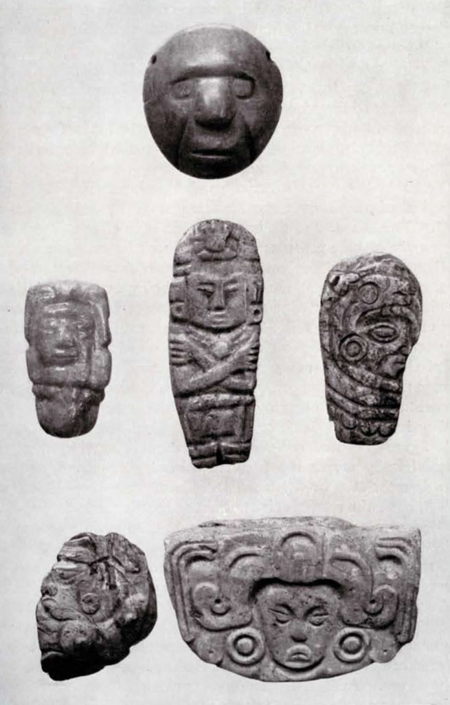 Six small jade objects with faces carved into them