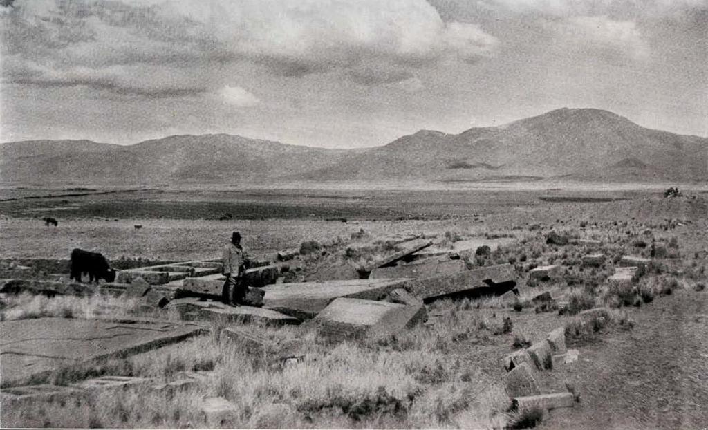View of a valley with a person standing amidst a ruin in the foreground