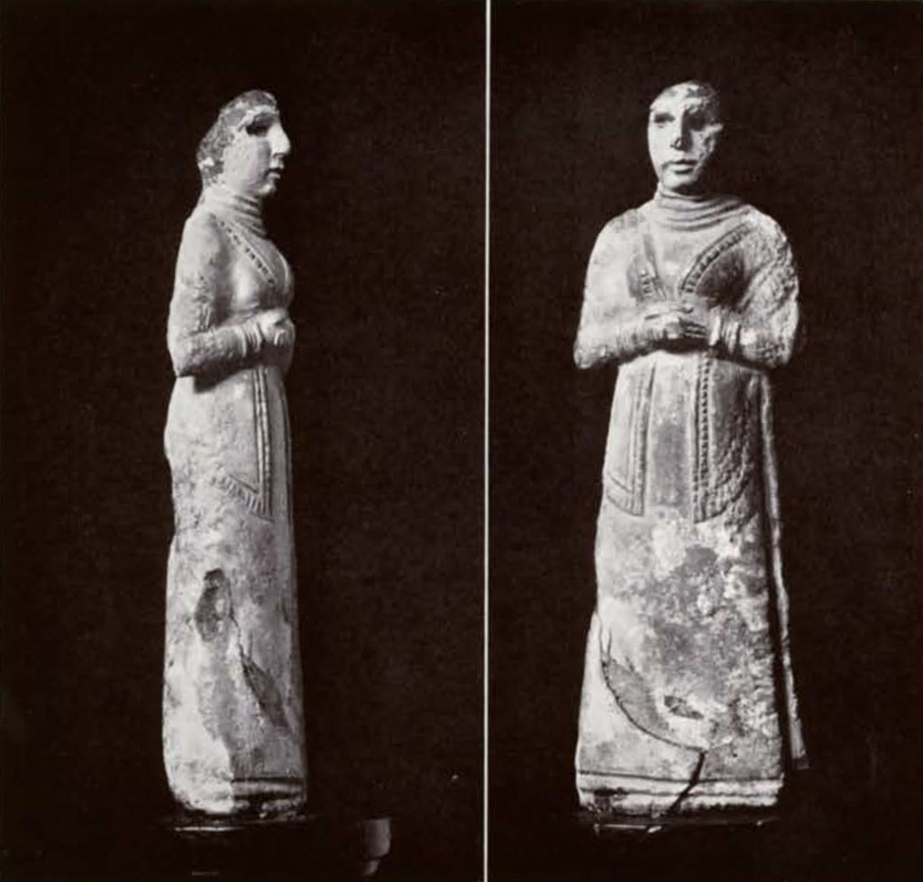 Front and side view of woman with hands clasped, in detailed dress