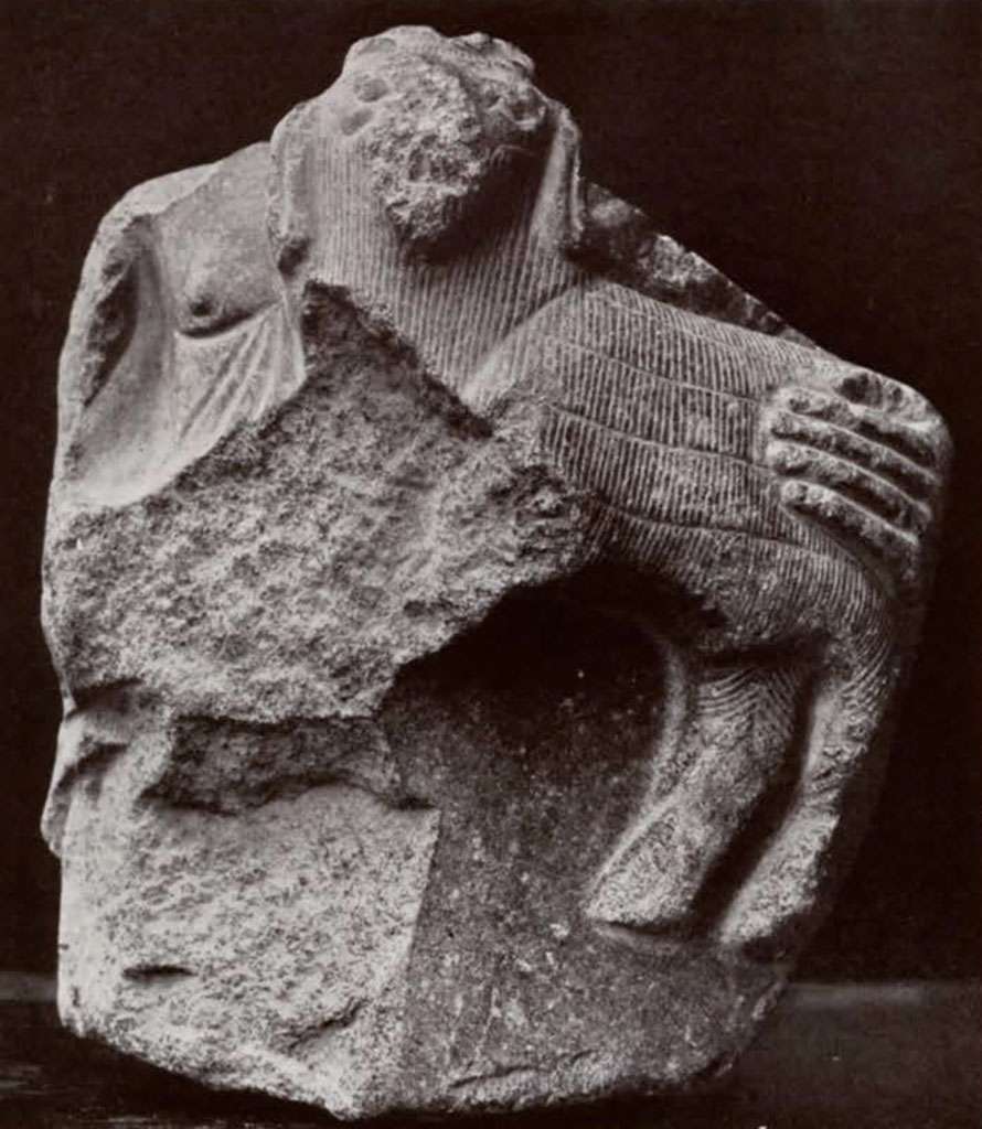 Fragment of statue showing a person holding a lamb or kid, most of person missing