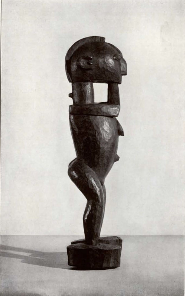 Wooden statuette of a standing figure with hands together under their chin, side view