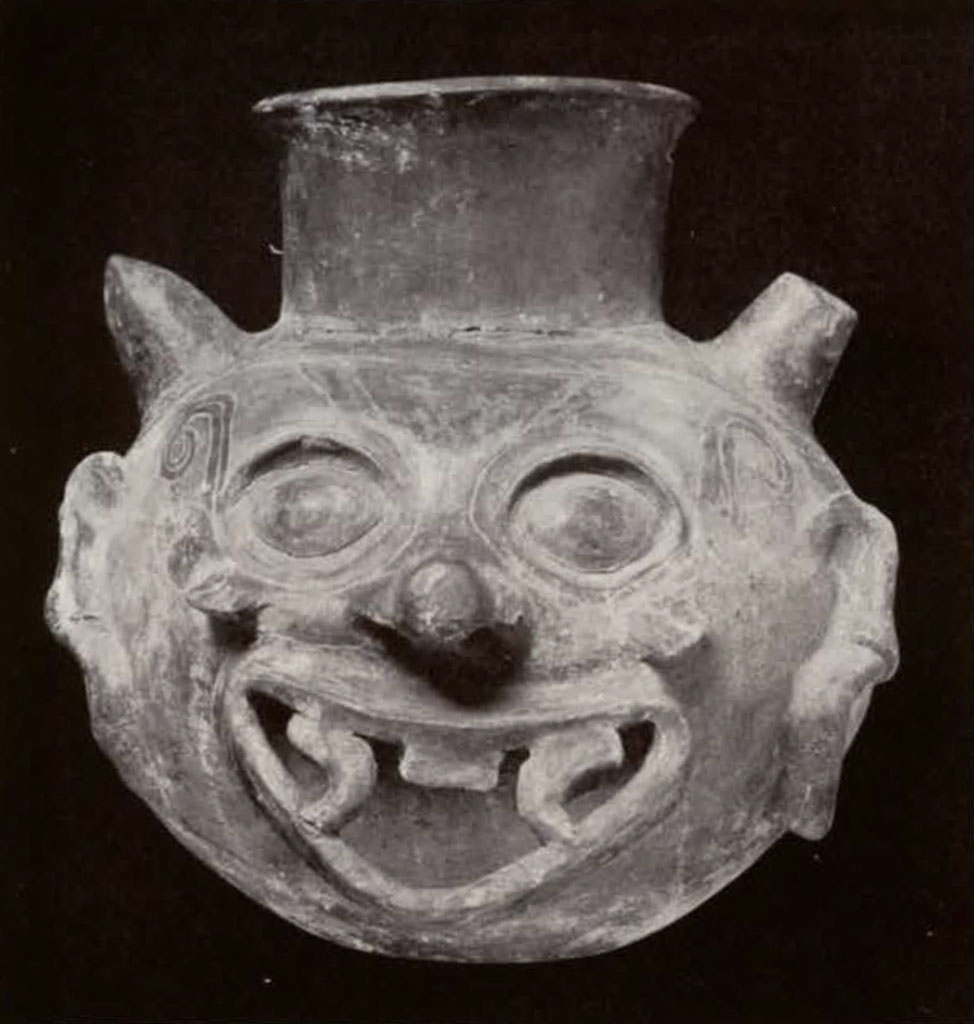 A vase in a grotesque face shape, with fangs and tongue