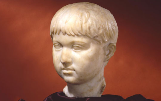 Marble bust of a child with chubby cheeks and short hair.