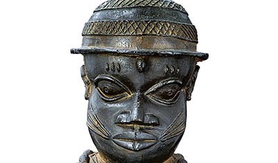 Nigerian brass figure of a man with facial scarification.